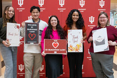 A group of law students holding signs that say "thank you" and "we love IU McKinney law".